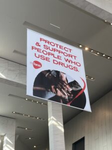 A banner from the Reform Conference that reads, in red, "Protect and support people who use drugs"